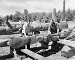 Mungo Martin and unidentified man carving and restoring totem poles